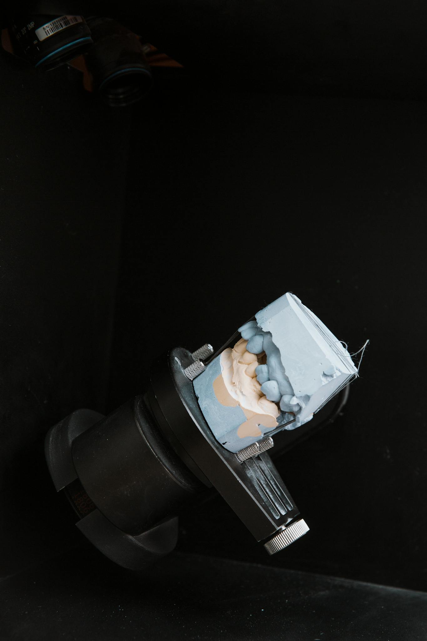 Dental mold displayed on apparatus in a lab setting; suitable for dentistry concept use.